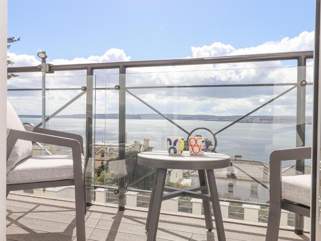 a table on a balcony with a view of the water at Bay Sea View in Torquay