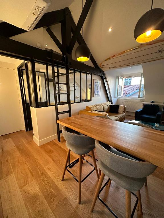 une salle à manger avec une grande table et des chaises en bois dans l'établissement Superbe appartement plein centre de Biarritz, à Biarritz