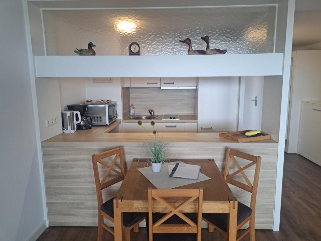 - une cuisine et une salle à manger avec une table et des chaises dans l'établissement Hanseatenhaus Appartement 67, à Westerland