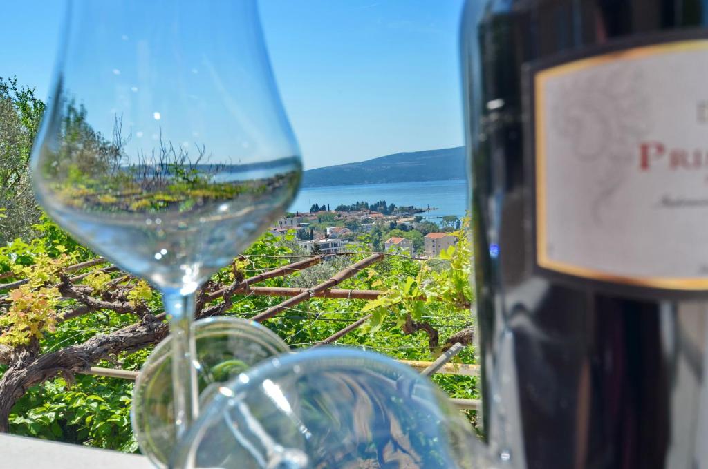 a wine glass sitting next to a bottle of wine at Porto Lastva Apartments in Tivat