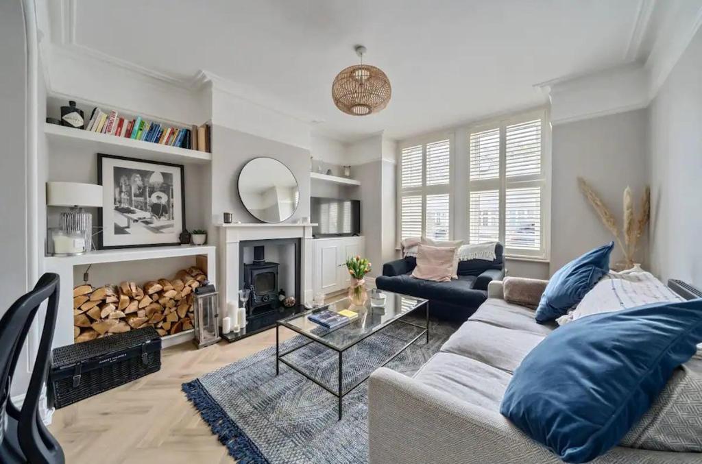 a living room with a couch and a fireplace at Pass the Keys Stylish Family Home in Hersham