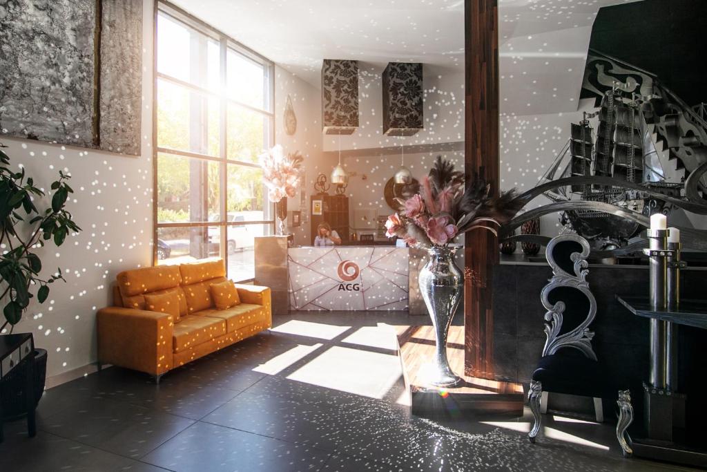 ein Wohnzimmer mit einem Sofa und einer Vase aus Blumen in der Unterkunft Hotel ACG in Los Villares
