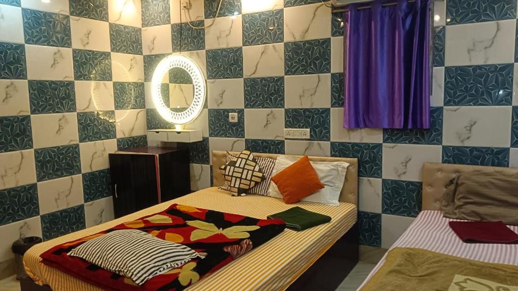 a bedroom with a bed with colorful blankets and a mirror at Hotel Air View in kolkata