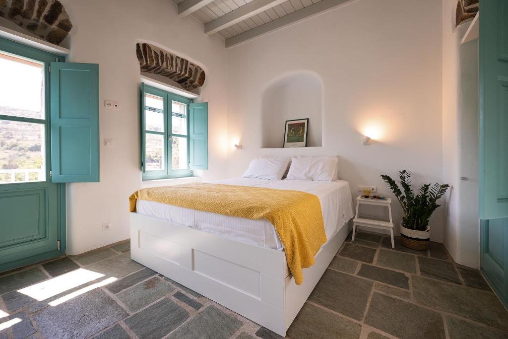 a bedroom with a white bed with a yellow blanket at The Architect's House, 3br villa in Naxos in Naxos Chora