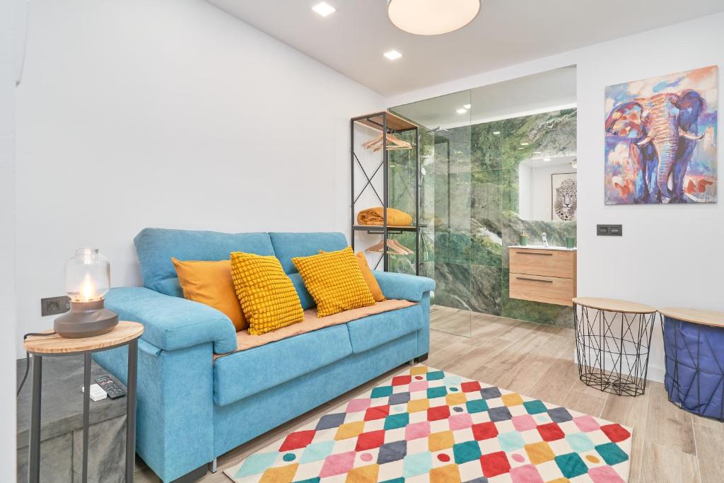 a blue couch with yellow pillows in a living room at Aunt Maria's House in Almuñécar