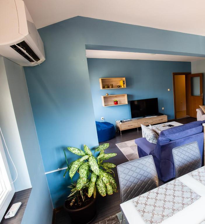 a living room with blue walls and a blue couch at "Life is Easy Apt" in Varna City