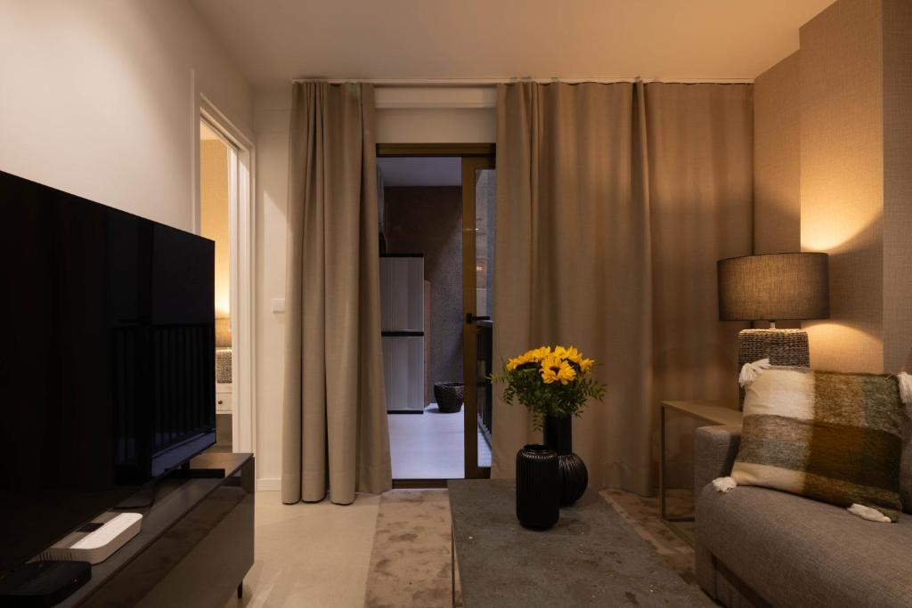 a living room with a television and a couch and a vase of flowers at Dorm4You Centro in Valencia