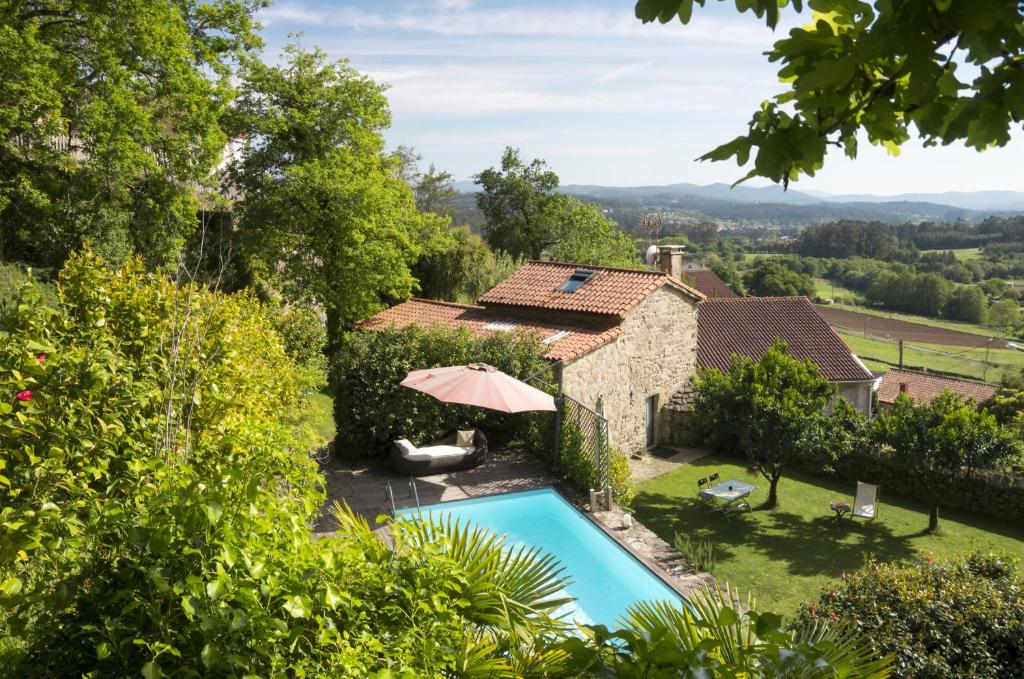 an external view of a house with a swimming pool at Casa de Afora Casa con piscina y jacuzzi privados in Santiago de Compostela