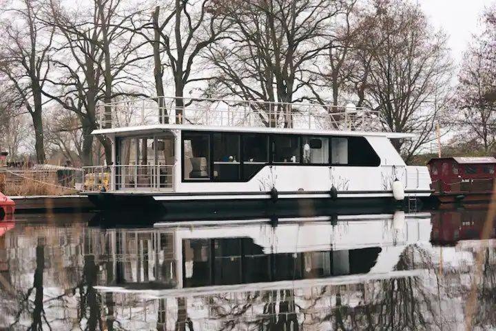 un barco en el agua con su reflejo en el agua en Hausboot-Tortuga, en Dömitz