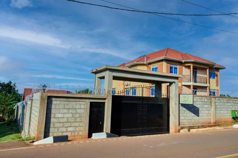 una vecchia casa con un cancello davanti di PB & J Guest House Entebbe a Entebbe