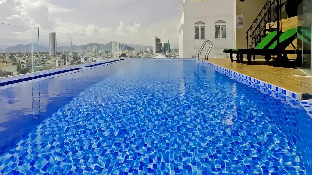 a large blue swimming pool with a view of a city at Central Hotel & Spa Danang in Da Nang