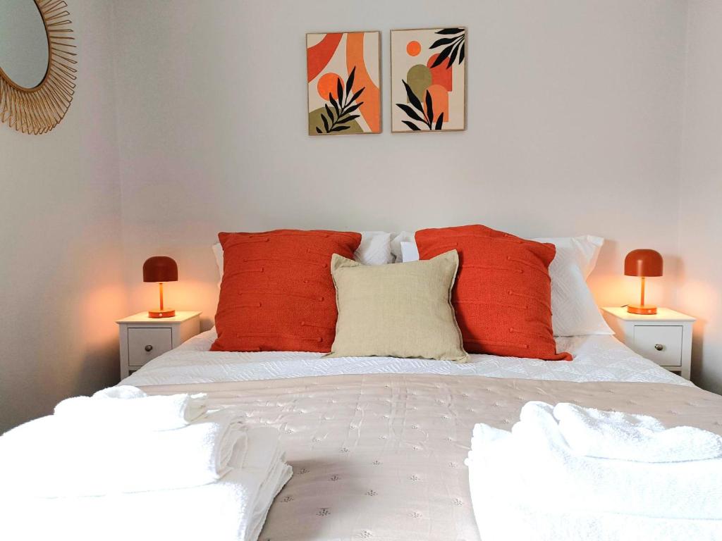 - une chambre avec un lit doté d'oreillers rouges et de 2 lampes dans l'établissement Charming Terrace Home in Whitchurch, à Whitchurch