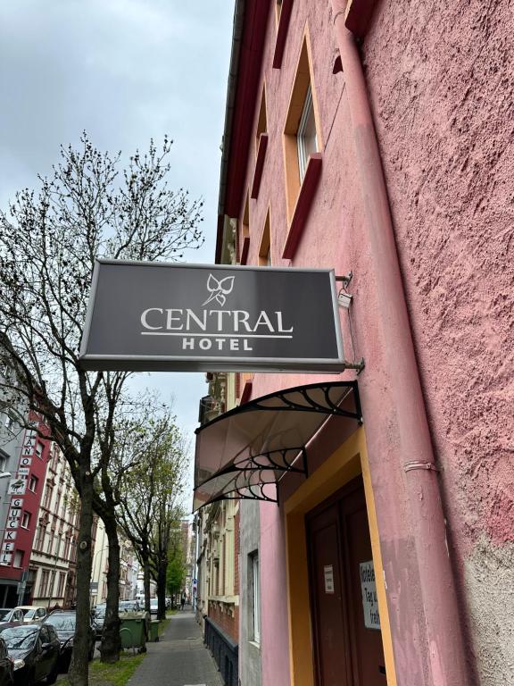 una señal para un hotel central en un edificio rosa en Central Hotel, en Offenbach