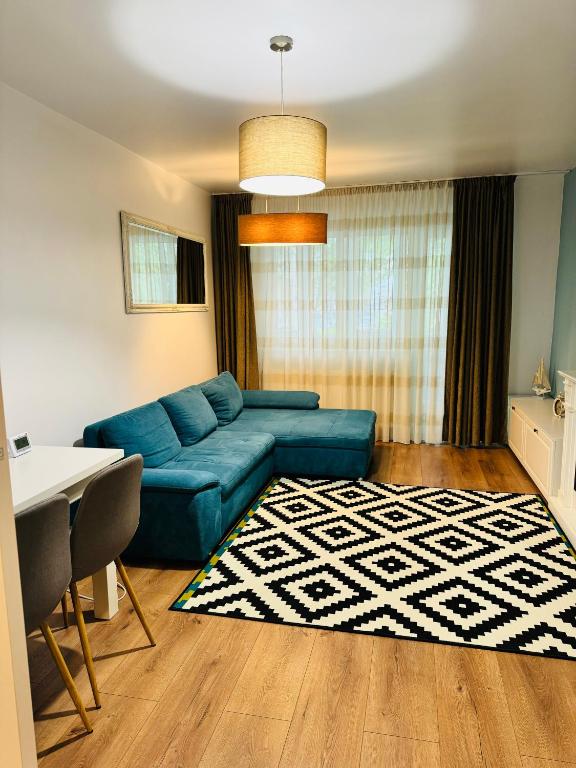 a living room with a blue couch and a rug at Blue Apartment in Cluj-Napoca