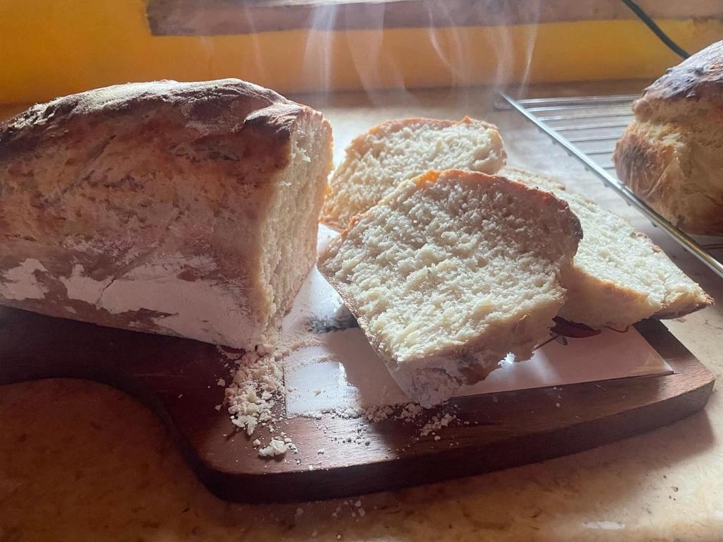 una hogaza de pan sentada en una tabla de cortar con pan en Siedlisko Pod Jaworem, en Domaszków