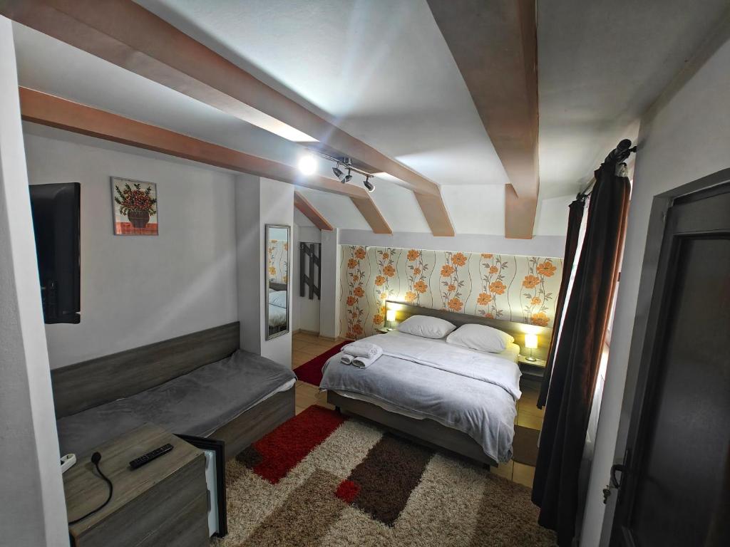 a small bedroom with a bed and a tv at Casa Miclau in Băile Herculane