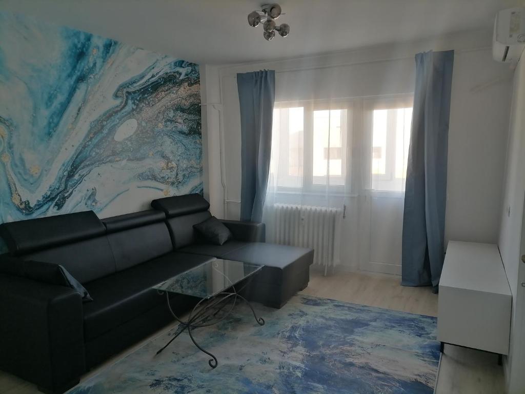 a living room with a black couch and a mural at Luxury 4-rooms, 2-bathrooms, Obor area in Bucharest