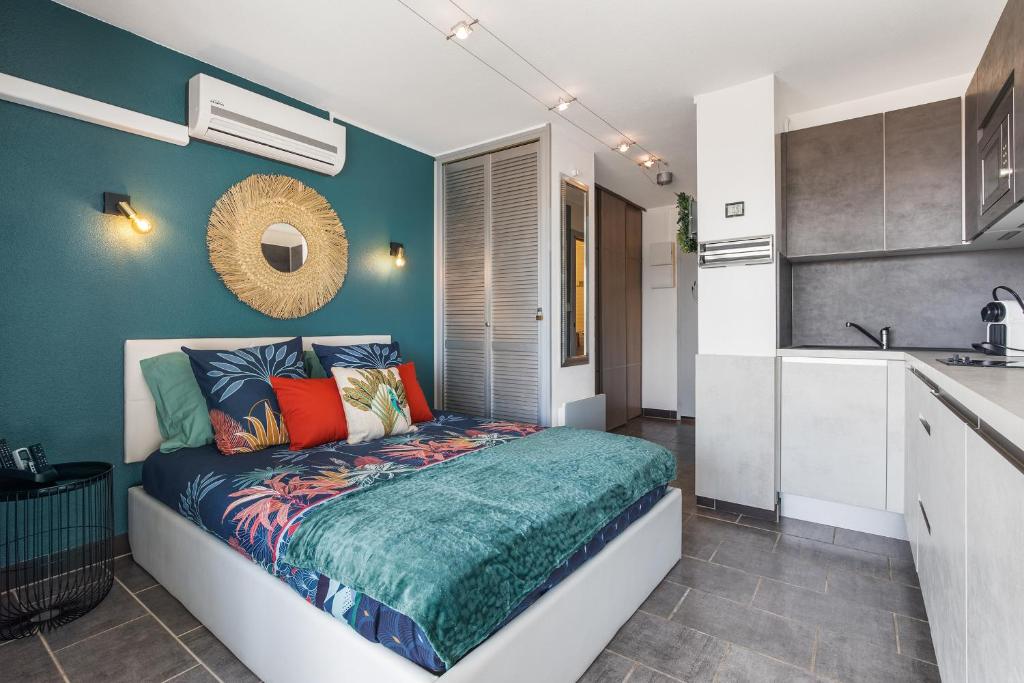 - une chambre avec un lit et des oreillers colorés dans l'établissement Cap Venus naturiste, au Cap d'Agde