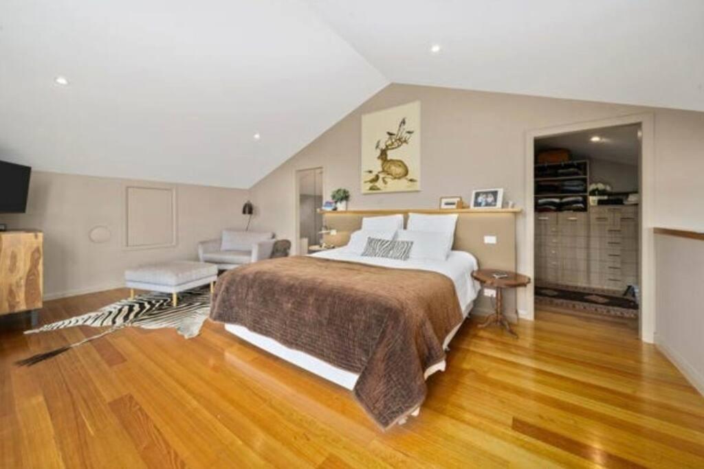 a bedroom with a large bed and a living room at Hobart comfy studio in Hobart