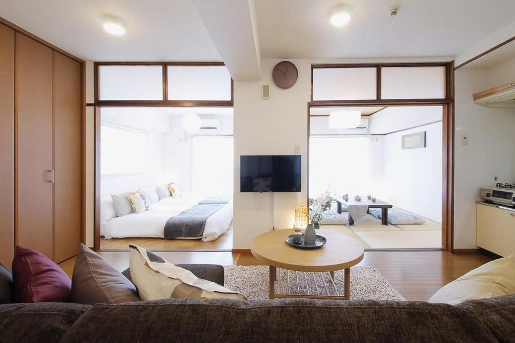 a living room with a couch and a bed at Mitao bld - 2 Bedroom Apt 4mins to PeacePark for 9ppl in Hiroshima