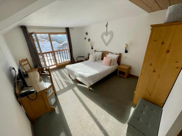 a bedroom with a bed and a balcony at Le Vancouver in La Plagne