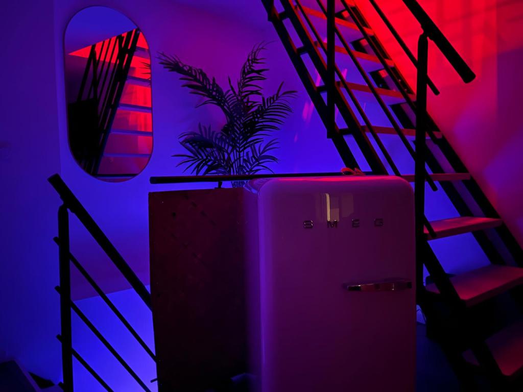 une chambre rose et violette avec un réfrigérateur dans l'établissement Suite romantique Love Nid 83, à La Farlède