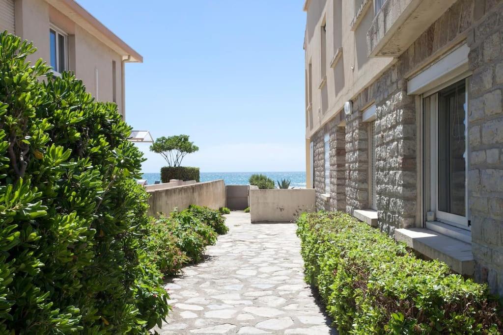 une passerelle à côté d'un bâtiment avec l'océan en arrière-plan dans l'établissement Appartement 2 chambres, avec terrasse/parking, à Palavas-les-Flots