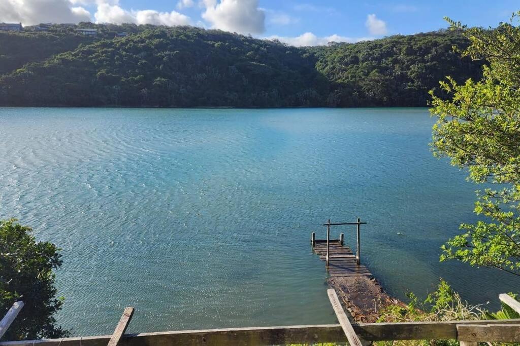 a dock on a lake with mountains in the background at On the River, Right by the Sea in East London