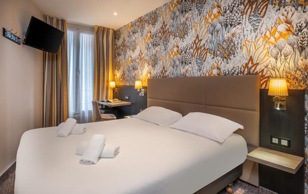 パリにあるTerminus Orléans Parisの花柄の壁紙を用いたベッドルーム1室(白い大型ベッド1台付)