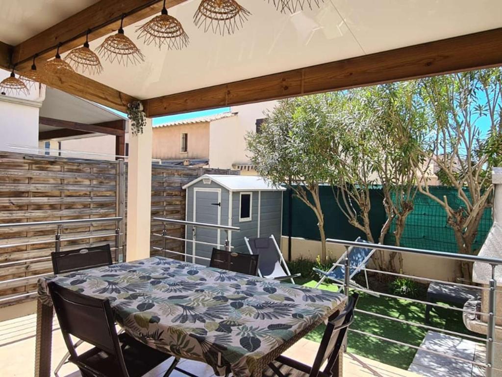un patio avec une table et des chaises sur un balcon dans l'établissement Appartement 3 pièces climatisé, terrasse, 6 couchages, parking privé, animaux admis - FR-1-326-673, à Marseillan