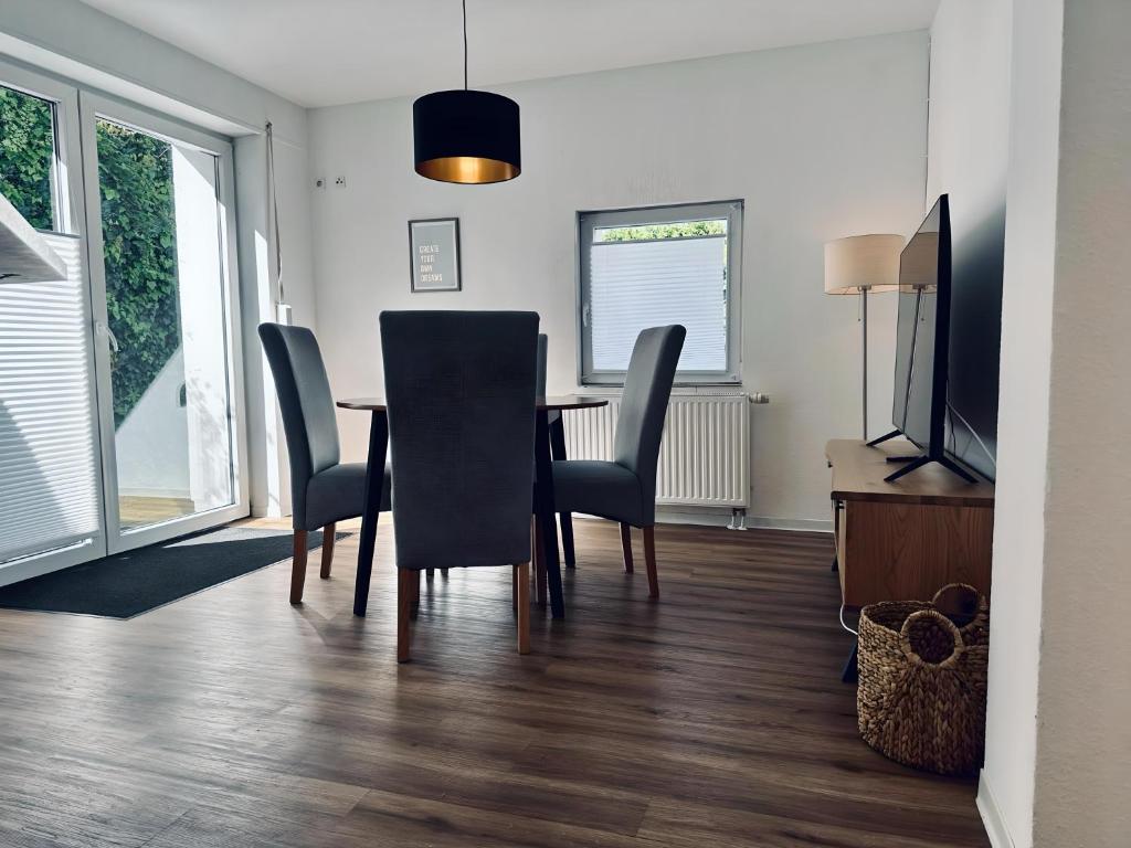 a dining room with a table and chairs and a television at FeWo Euregio II - mit Terrasse in Nordhorn