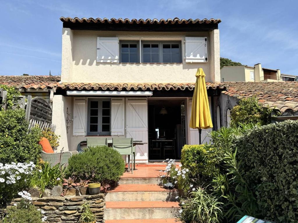 une maison avec un parasol jaune et une terrasse dans l'établissement Mas 2 chambres avec vue mer, piscine, Wi-Fi - FR-1-726-10, à La Croix-Valmer