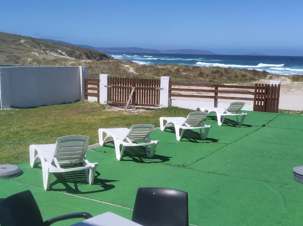 een groep ligstoelen op het strand bij Coruña Backpackers Hostel in Carballo