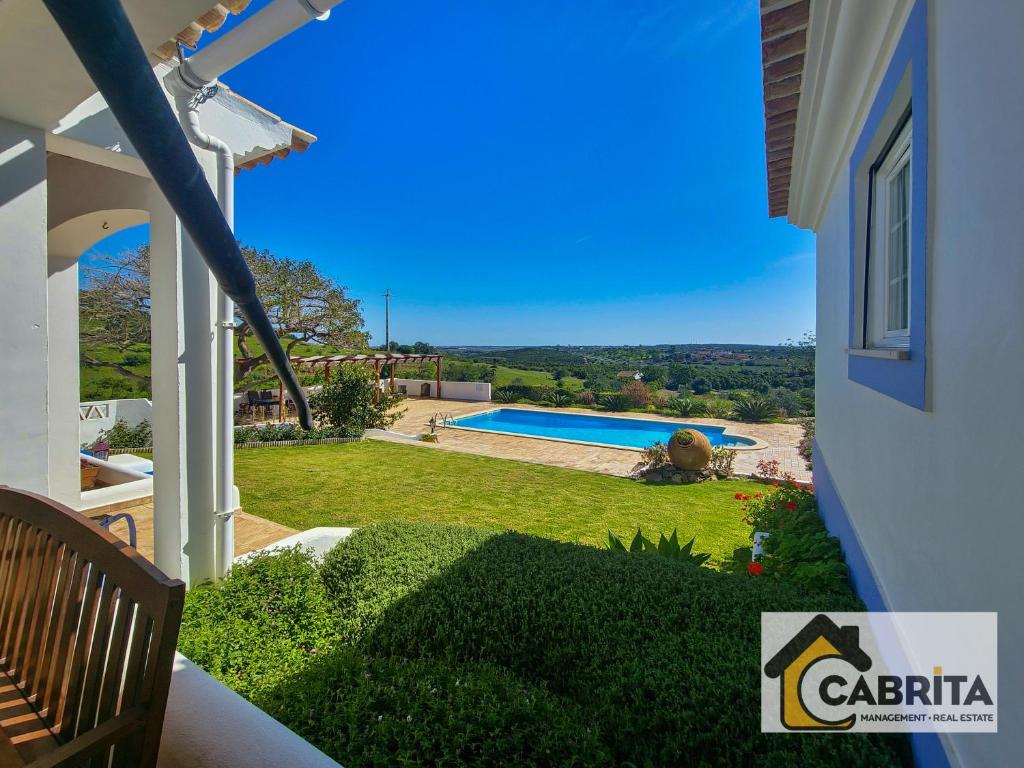 een uitzicht vanaf het balkon van een huis met een zwembad bij Quinta dos Medronheiros in Altura