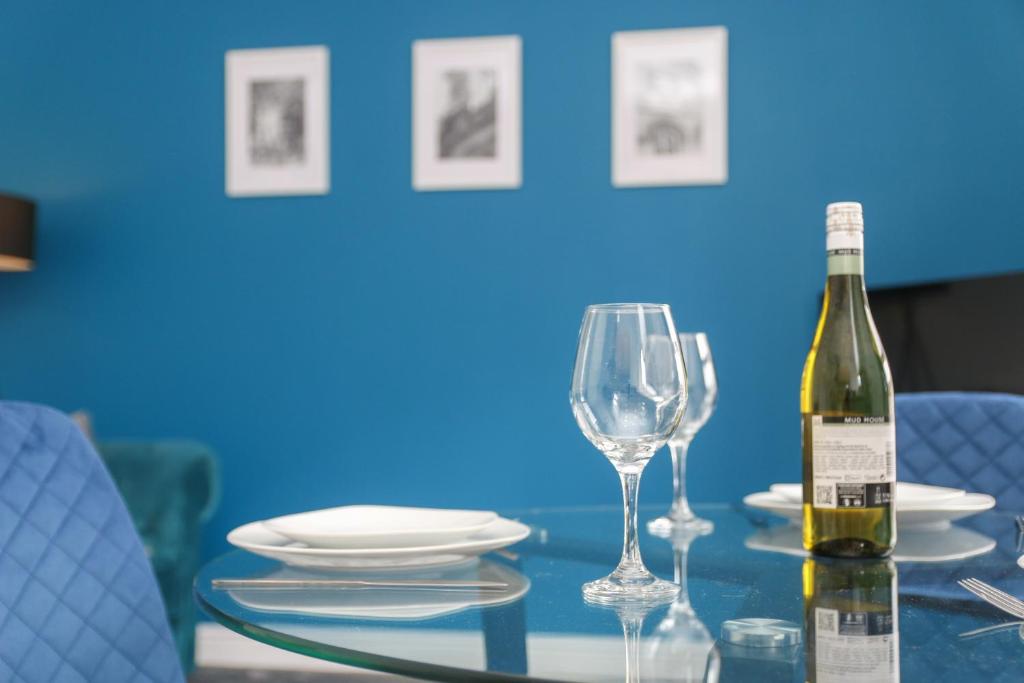 uma garrafa de vinho sentada numa mesa com copos em Inviting 2-Bed apartment - Perfect for Contractors and Business Travellers em Retford