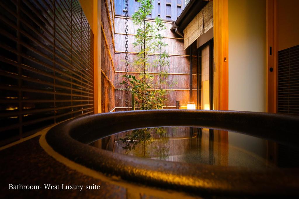 Una gran bañera en una habitación con una planta en Kyonoyado Gekkoan en Kyoto