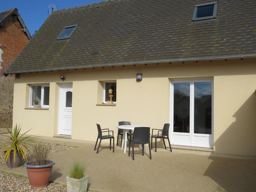 une maison avec un patio avec une table et des chaises dans l'établissement La cavale, à Guiseniers