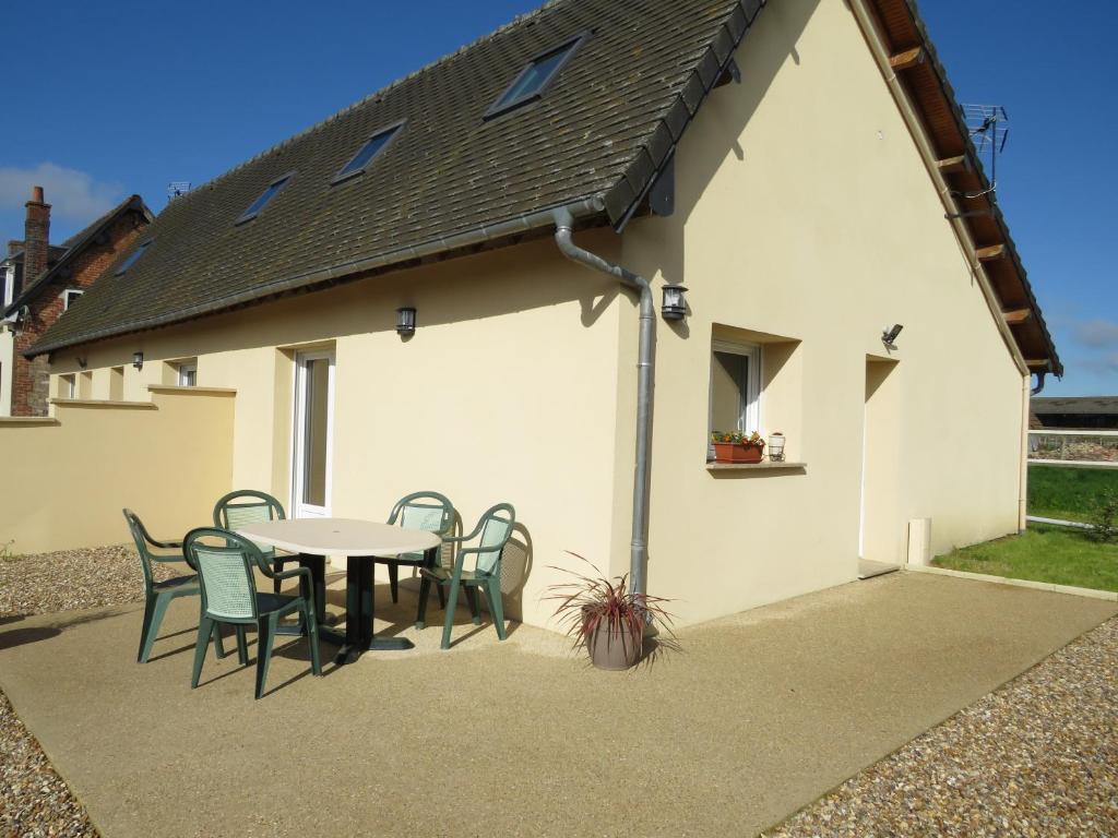 un patio avec une table et des chaises devant une maison dans l'établissement La Pellegrine, à Guiseniers