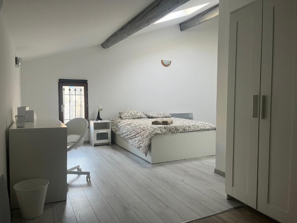 une chambre blanche avec un lit et un bureau dans l'établissement CASA KILMAINE, à Tarascon