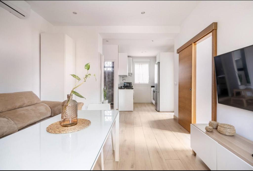 a white living room with a couch and a table at Acogedor y precioso apartamento en Sevilla in Seville