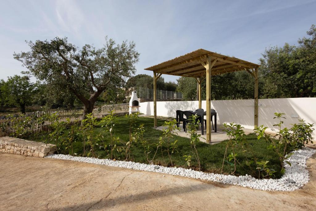 - un kiosque avec une table de pique-nique dans le jardin dans l'établissement Porta Sugli Ulivi, à Monopoli