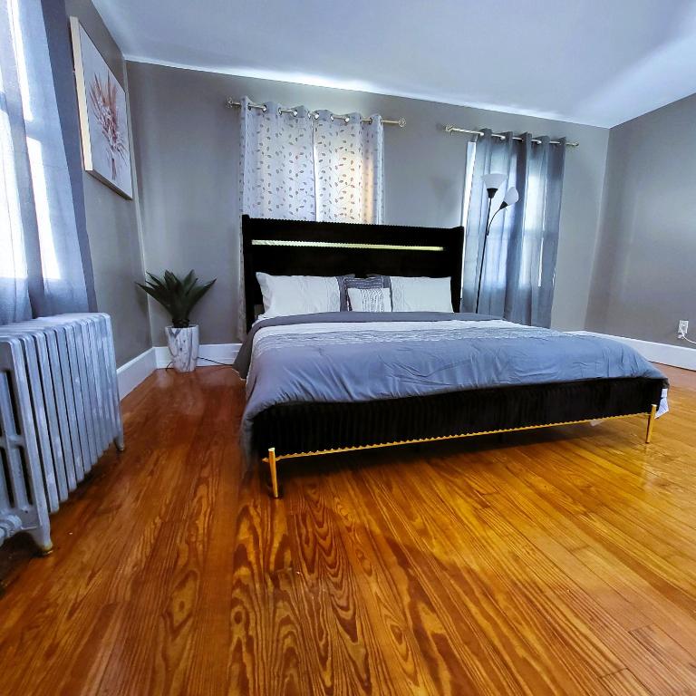 a bedroom with a bed and a wooden floor at Grandeur Living close to Boston in Stoughton