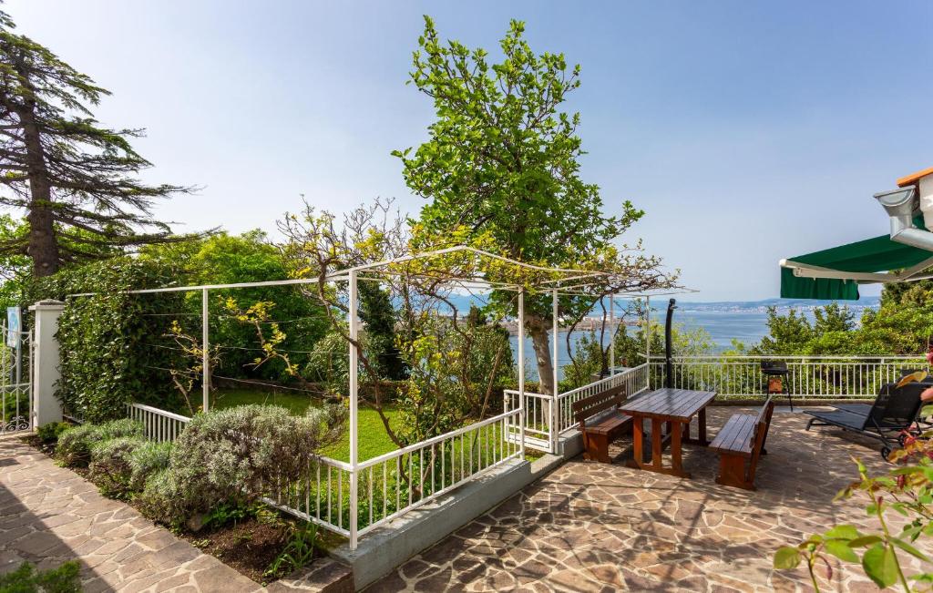 a patio with a wooden bench and a fence at 3 Bedroom Pet Friendly Home In Omisalj in Omišalj