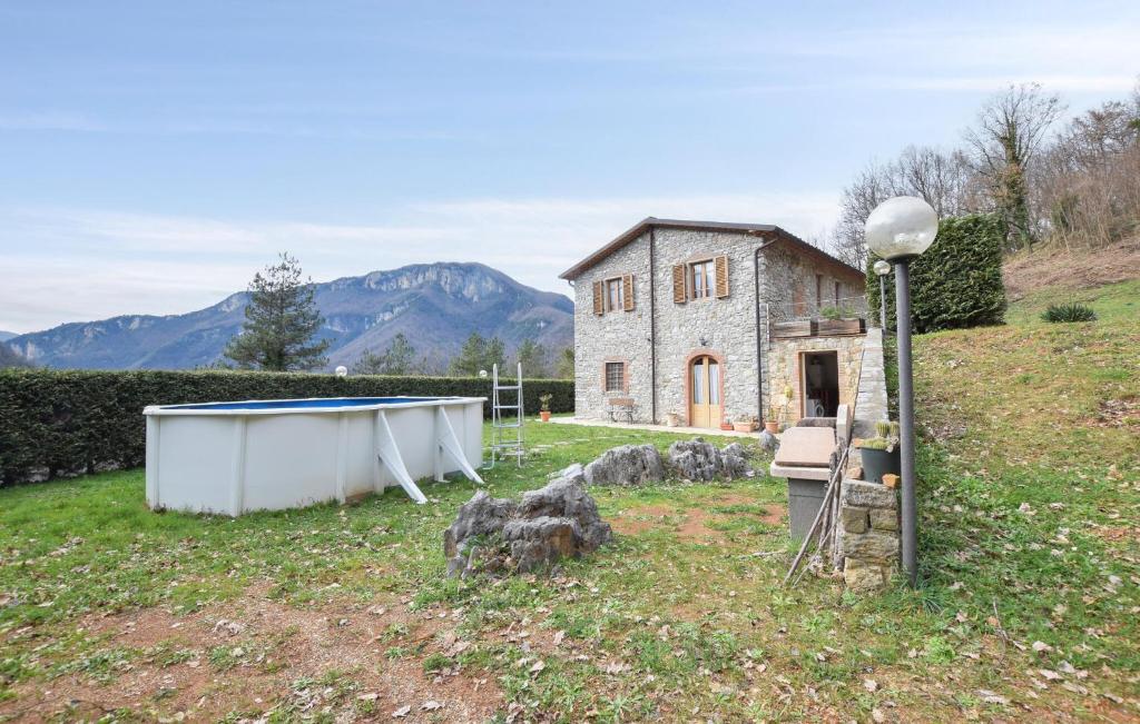 een oud stenen huis met een zwembad in een veld bij Gorgeous Apartment In Borgo A Mozzano With Wifi in Borgo a Mozzano
