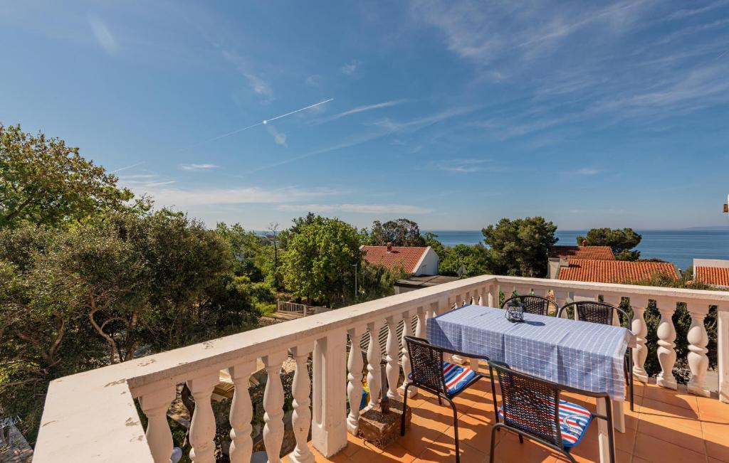 a table on a balcony with a view of the ocean at Nice Apartment In Potocnica With House Sea View in Borovići