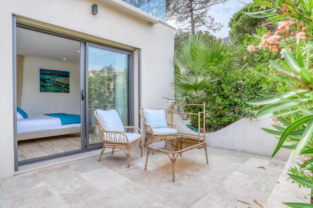 a patio with two chairs and a bed at Akwabay - Les Villas du Cap in Le Lavandou