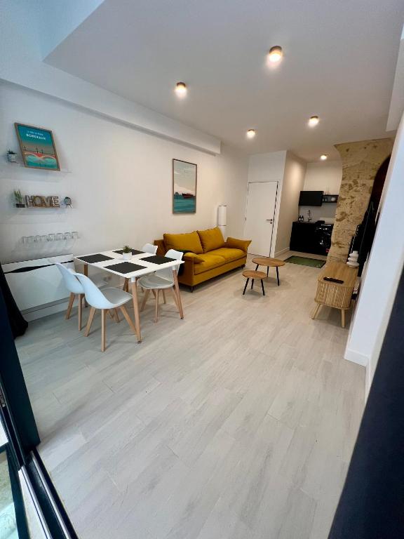 un salon avec une table, des chaises et un canapé dans l'établissement Duplex Atypique, à Bordeaux