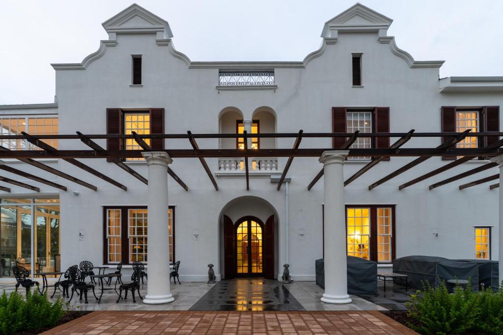 duży biały budynek z kolumnami i oknami w obiekcie Wytham Manor House w Kapsztadzie