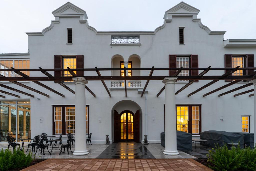 a large white building with columns and windows at Manor Boutique House in Cape Town