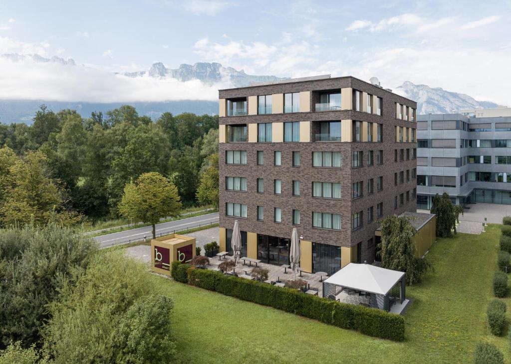 una vista aérea de un edificio con montañas en el fondo en b-smart hotel Bendern, en Bendern